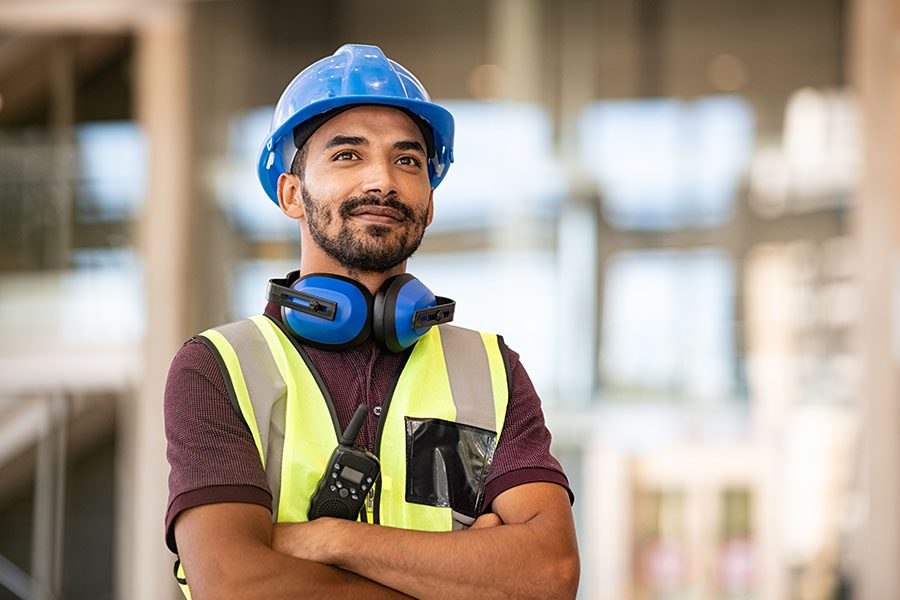 Specialized Business Insurance - Construction Worker Standing in Front of a Construction Site With Arms Crossed